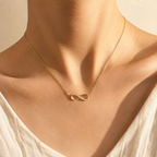 Collar Infinito Amor Eterno dorado puesto en el cuello, luz cálida de atardecer